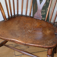 Antique English Windsor armchair in elm with uneven seat and ash stick back