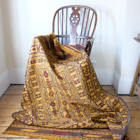 Draped over a chair - Antique Anatolian kilim rug with saffron ground and geometric motifs