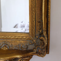 Late Victorian gilt wall mirror with original bevelled mirror plate and cherub shelf detail