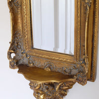 Close up view of the Cherub Sconce Shelf of a Late Victorian gilt wall mirror with original bevelled mirror plate and cherub shelf detail