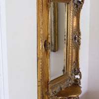 Side profile view of a Cherub Sconce Shelf of a Late Victorian gilt wall mirror with original bevelled mirror plate and cherub shelf detail