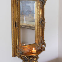 Late Victorian gilt wall mirror with original bevelled mirror plate and cherub shelf detail