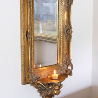 Late Victorian gilt wall mirror with original bevelled mirror plate and cherub shelf detail