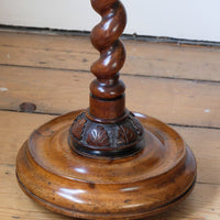 carved foliate collar, adding further depth and refinement before transitioning into a substantial circular platform base. - Rare Victorian walnut barley twist candle and wine stand with brass sconce and carved foliate decoration, circa 1870
