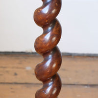 Close up of the barley twist column on a Rare Victorian walnut barley twist candle and wine stand with brass candle sconce and carved foliate decoration, circa 1870