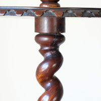 Close up of the carved tabletop edge detail on a Rare Victorian walnut barley twist candle and wine stand with brass candle sconce and carved foliate decoration, circa 1870