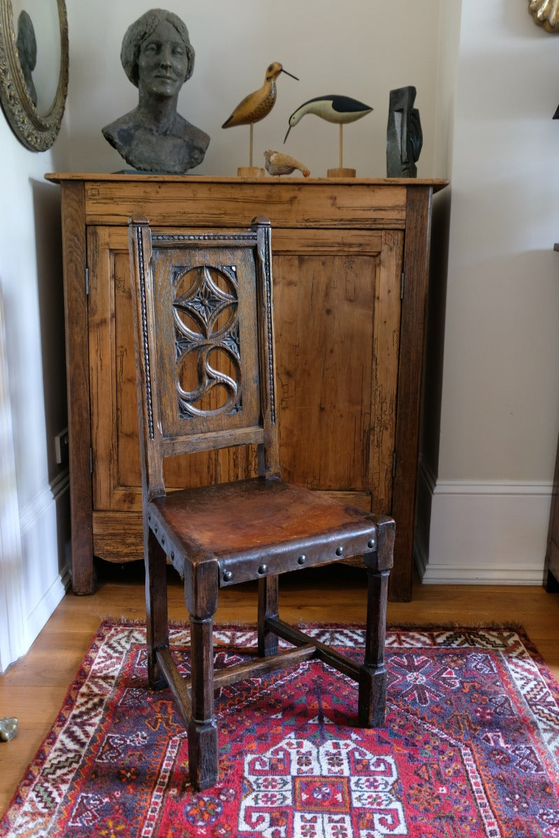 Carved elm hall chair circa 1900 with hide seat front view