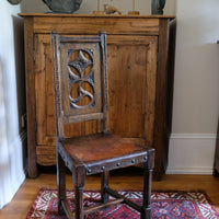 Carved elm hall chair circa 1900 with hide seat front view