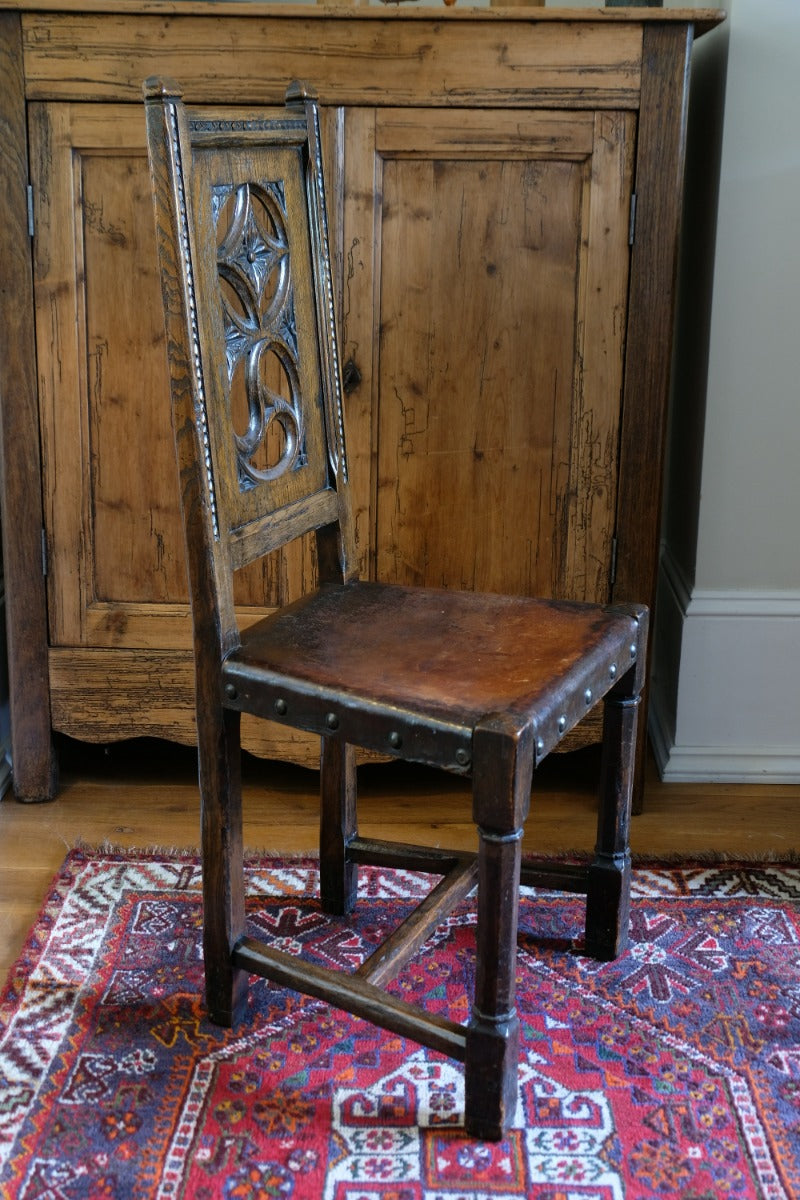 Carved elm hall chair circa 1900 with hide seat front view