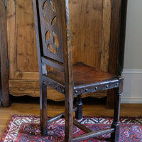 Carved elm hall chair circa 1900 with hide seat front view