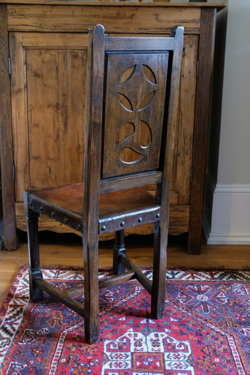 Carved elm hall chair circa 1900 with hide seat front view