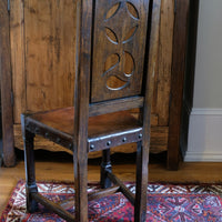 Carved elm hall chair circa 1900 with hide seat front view