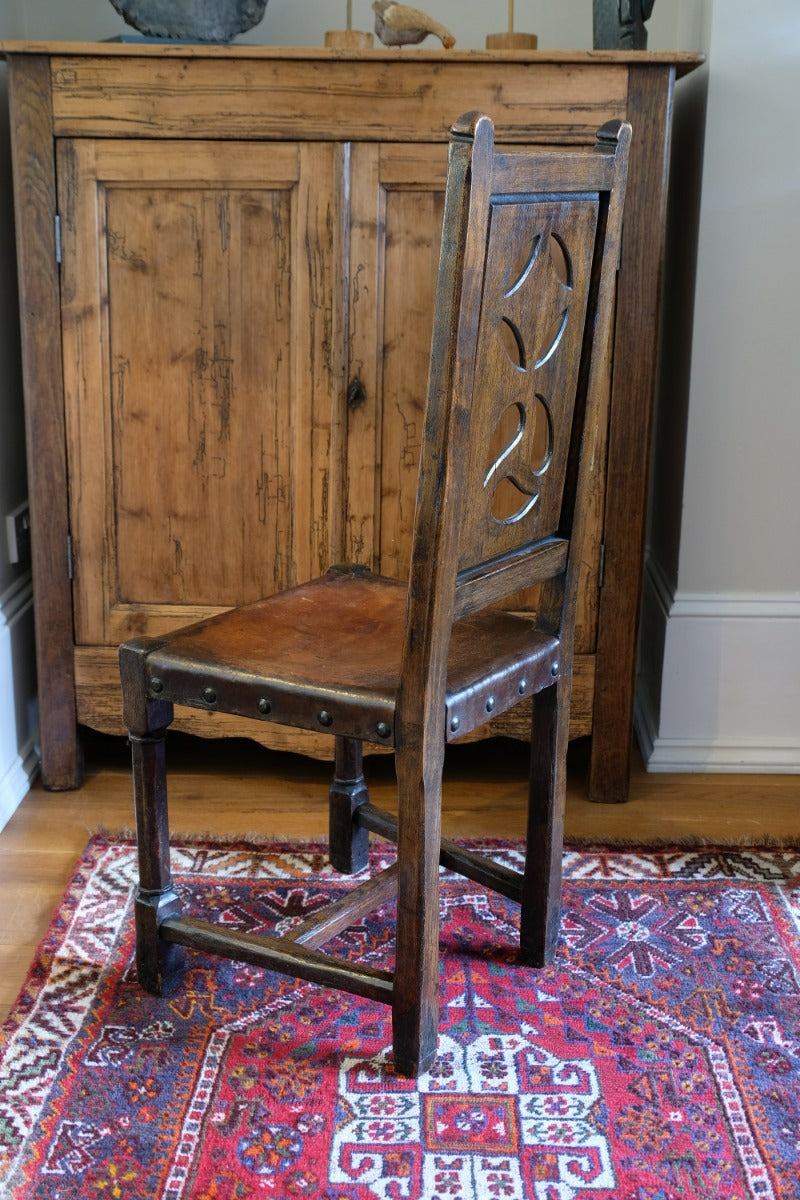 Carved elm hall chair circa 1900 with hide seat front view