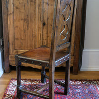 Carved elm hall chair circa 1900 with hide seat front view