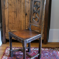 Carved elm hall chair circa 1900 with hide seat front view