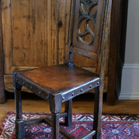 Carved elm hall chair circa 1900 with hide seat front view