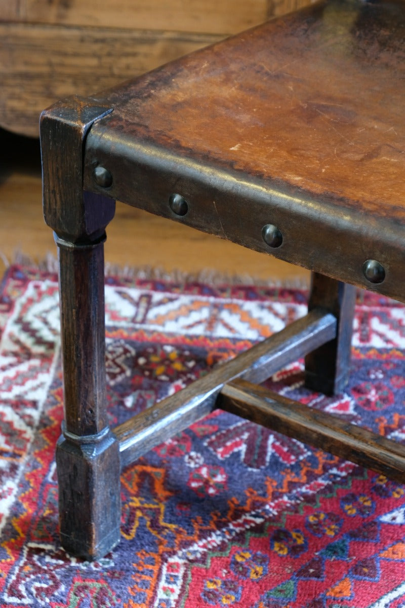 Hide upholstered seat with brass studs on antique elm chair