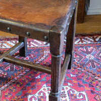 Hide upholstered seat with brass studs on antique elm chair