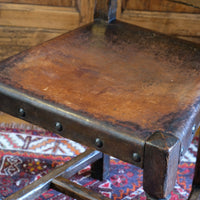 Hide upholstered seat with brass studs on antique elm chair