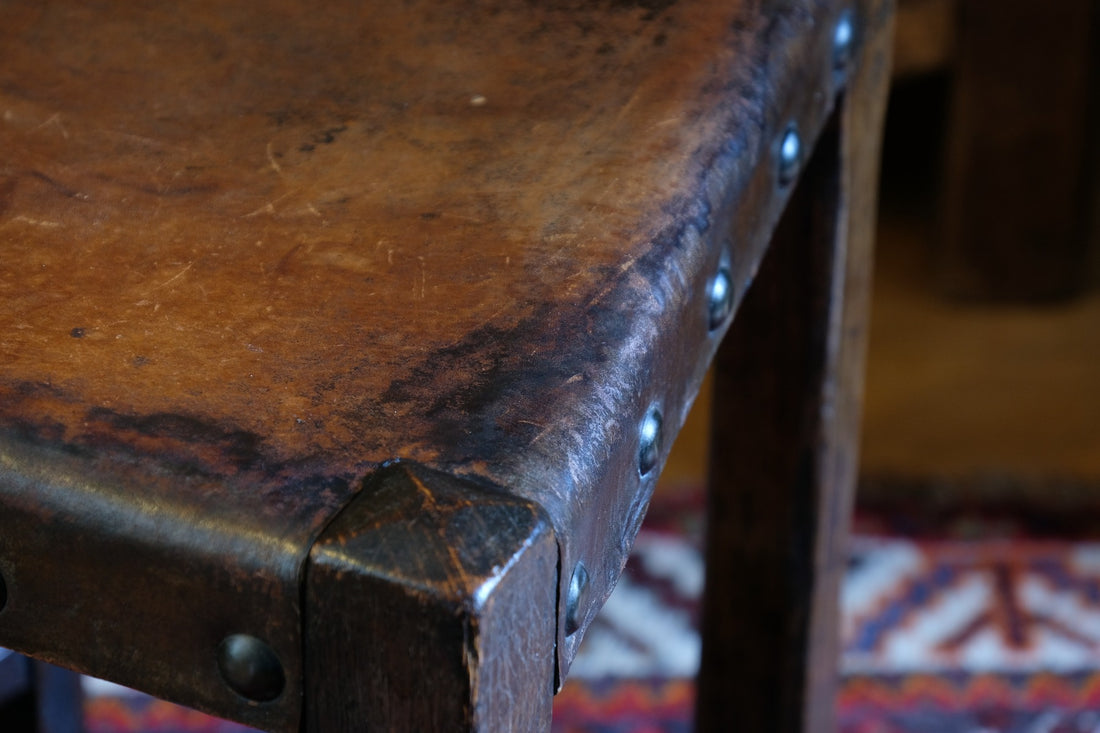 Hide upholstered seat with brass studs on antique elm chair