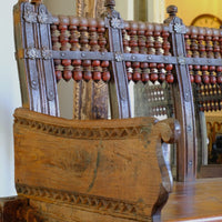 Close up side view on a Late 19th Century Gujarati Hardwood Hall Bench with Original Polychrome Finish, Turned Gallery Back and Brass Rosette Mounts