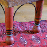 The surviving original terracotta polychrome legs and iron work on a Late 19th Century Gujarati Hardwood Hall Bench with Original Polychrome Finish, Turned Gallery Back and Brass Rosette Mounts