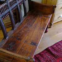 The old bench seat on a Late 19th Century Gujarati Hardwood Hall Bench with Original Polychrome Finish, Turned Gallery Back and Brass Rosette Mounts