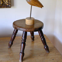 Antique English dairy milking stool with four turned legs and original dark painted finish