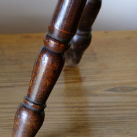 Antique English dairy milking stool with four turned legs and original dark painted finish