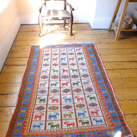Vintage Persian Sumak flatweave rug with stylised goat and geometric motifs on an ivory ground