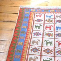 Vintage Persian Sumak flatweave rug with stylised goat and geometric motifs on an ivory ground