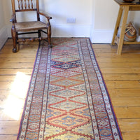 Different light shining on the Mid-20th Century North-West Persian ivory ground hand-knotted wool runner with fourteen hooked lozenge medallions