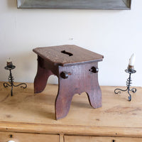 Antique Arts and Crafts oak low stool with S-shaped carrying handle, fret-cut arches and exposed keyed through-tenons, circa 1900.