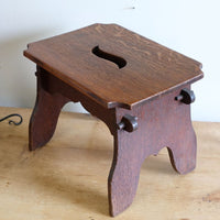 Antique Arts and Crafts oak low stool with S-shaped carrying handle, fret-cut arches and exposed keyed through-tenons, circa 1900.