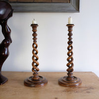 Pair of tall antique oak open barley twist candlesticks with original brass sconces and weighted circular bases