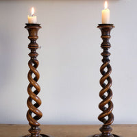 Pair of tall antique oak open barley twist candlesticks with original brass sconces and weighted circular bases