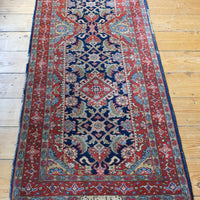 Indigo field and repeating diamond medallions of the Persian runner