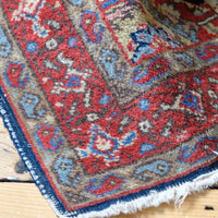 Corner detail showing the hand-knotted borders and dark-blue side binding
