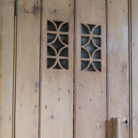 Antique pine cupboard, circa 1890–1910, with a boarded door, two pierced ventilation panels and a plinth base