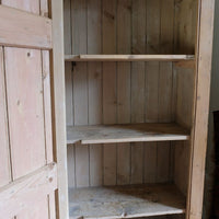 Antique pine cupboard, circa 1890–1910, with a boarded door, two pierced ventilation panels and a plinth base