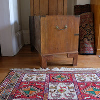 Side view of mahogany campaign chest showing carrying handle and shaped bracket feet