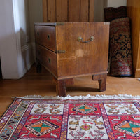 Side view of mahogany campaign chest showing carrying handle and shaped bracket feet