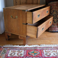 Side view of mahogany campaign chest showing carrying handle and shaped bracket feet