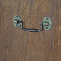 Side view of mahogany campaign chest showing carrying handle and shaped bracket feet