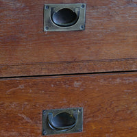 Close-up of recessed brass campaign drawer handle and original keyhole escutcheon.