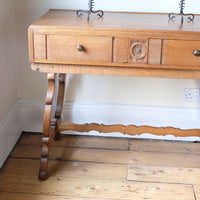 Side shot on the Arts & Crafts oak console table by Beresford & Hicks with two drawers and shaped trestle supports