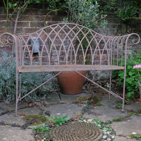 Painted wrought iron garden bench with Gothic arch back, scroll armrests and slatted seat
