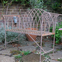Painted wrought iron garden bench with Gothic arch back, scroll armrests and slatted seat