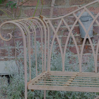 Painted wrought iron garden bench with Gothic arch back, scroll armrests and slatted seat