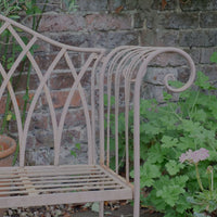 Painted wrought iron garden bench with Gothic arch back, scroll armrests and slatted seat